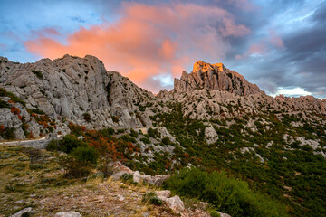 Colorful sky from the setting sun over Tulovegrede in the Croatian Velebit mountains. - obrazy, fototapety, plakaty