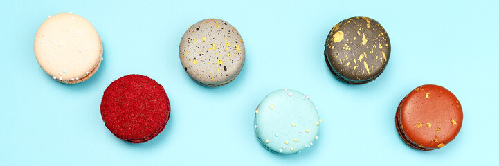 Six multicolored macaroons on a blue background