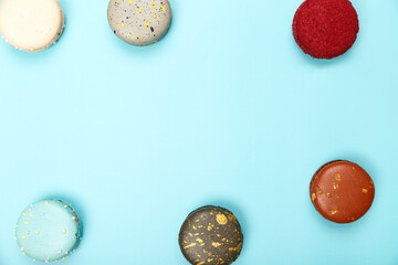 Six multicolored macaroons on a blue background