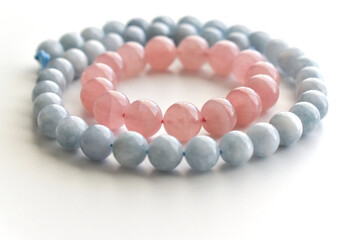 Rose quartz bracelet and aquamarine strand on the table.