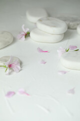 Fototapeta na wymiar Spa stones and fresia flower on white table