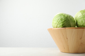 Ripe white cabbage on light marble table. Space for text