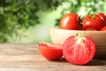 Fresh ripe tomatoes on wooden table. Space for text