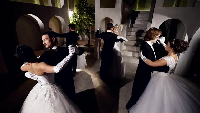 four dancers pairs are dancing in ballroom, beautiful women and men are spinning in dance