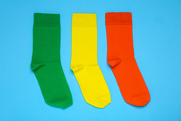 Different socks on light blue background, flat lay