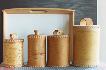 Organization of storage in the kitchen. Pasta, rice and cereal in natural tree bark containers on a kitchen shelf. Use of natural materials for food storage.