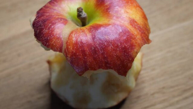 A stub of a large apple. Half-eaten one red apple close-up. The core of an apple of the gala variety, rotation. Macro video.