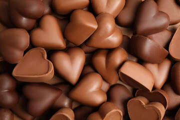 Fototapeta premium Tasty heart shaped chocolate candies as background, top view. Valentine's day celebration