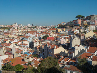 Fototapeta na wymiar The beautiful skyline of Lisbon, Portugal, with red roofed, colorful houses in the Alfama district during a sunny day.