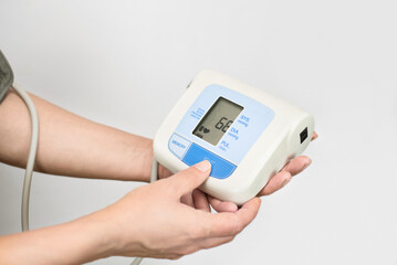 A woman holds a tonometer in her hands and measures the heartbeat, pulse, after measuring blood...
