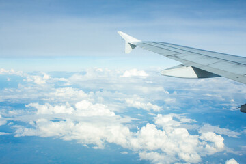 Fototapeta na wymiar Airplane Window View with Airplane wing and Blue Sky