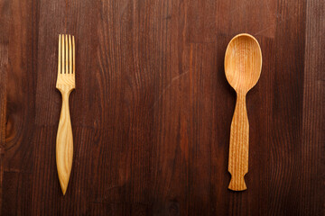 Wooden spoon and fork on dark brown wooden background.copy space.