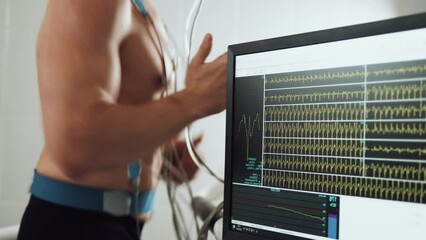 Muscular man athlete running on treadmill in gym for monitoring test his sport performance. Sportsman in sports science lab measuring cardio respiratory, heart check. - Powered by Adobe