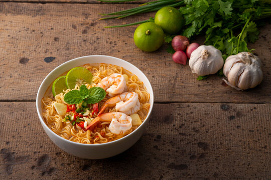 Spicy instant noodles soup with shrimp ,tom yum kung on wooden background