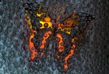 The yellow-red butterfly silhouette is located against the dark background. Abstract fantasy. 3D render. 