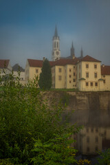 Vyssi Brod town in summer foggy morning with color buildings and nature