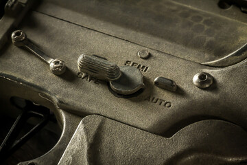 Close-up shot of selective fire of khaki camouflage M4 assault rifle, to be adjusted to fire in...