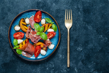 Grilled peach salad with mozzarella, prosciutto ham, red tomato, green basil and soy sauce