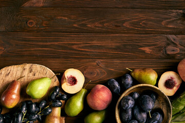 Healthy organic food, diet concept.
Beautiful raw fruits assortment on a woody brown. Top view, copy space.