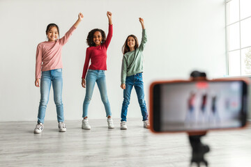 Three Diverse Blogger Girls Making Video On Smartphone Indoors
