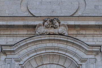 Two angels sculpted on the facade of a church in the town of Saint Claude in the Jura in France