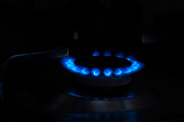 Gas cooker with burning fire propane gas. Blue flames on gas stove burner isolated on black background
