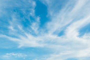 bright blue sky warm background with white clouds cumulus floating soft focus, copy space.