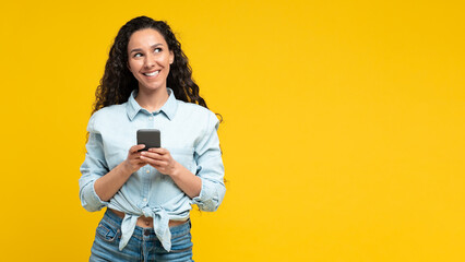 Cheerful Arabic Woman Using Mobile Phone On Yellow Background, Panorama