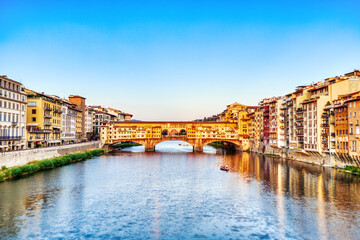 Obraz premium Golden Sunset over Ponte Vecchio Bridge with Reflection in Arno River, Florence