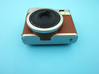   Antique vintage film camera front view isolated on blue background.    