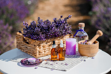 Dropper bottle with lavender cosmetic oil or hydrolate against lavender flowers field as background...