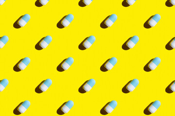 a pattern of roller deodorant in blue and white on a yellow background hard shadows