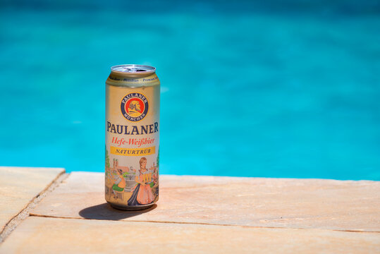 German Paulaner weiss beer can  at a pool party by the swimming pool