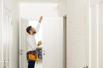 Fototapeta na wymiar High Angle View Of Male Carpenter With Screwdriver Fixing Door Lock