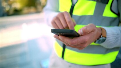 Phone, hands and communication with an engineer, construction worker or building planner working in his office. Building manager reading a text message on a mobile smartphone while outside on a site
