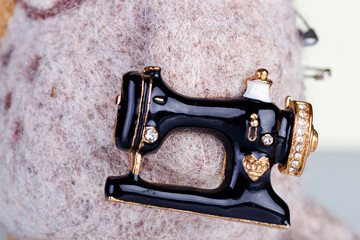 small pillow for needles in the form of an owl and a sewing machine on a white background