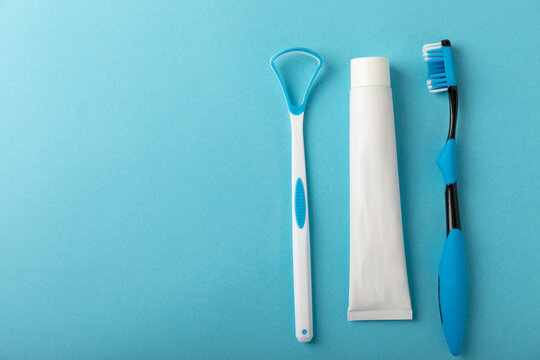 Toothbrush and toothpaste with tooth model on blue background with copy space. Flat lay. Oral hygiene. Oral Care Kit. Dentist concept.
