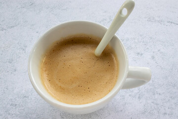 White cup of Cappucino coffee. Instant protein coffee in cup on table. Preparing coffee process. Top view, flat lay, copy space 