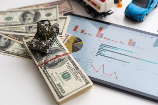 a toy tank, dollars and a tablet