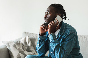 Serious Black Guy Talking On Phone Sitting At Home