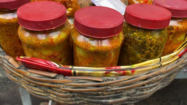 Close up shot of street vendors selling wide variety of pickles or aachar in his shop
