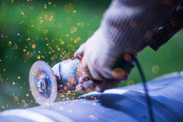 Man working with grinder saw, close up view on tool. Electric saw and hands of worker with sparks....