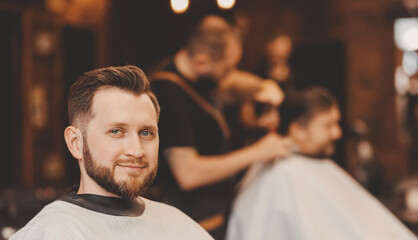 Portrait smile client man in barber chair, hairdresser styling hair. Concept barbershop, vintage...