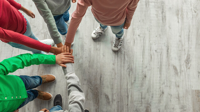 Unrecognizable Kids Putting Hands Together Standing Indoors, Top View - Powered by Adobe