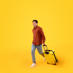 Male Tourist Walking With Luggage Going On Vacation, Yellow Background