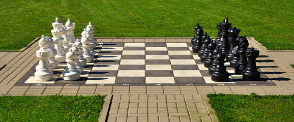 big outdoor chess on a green lawn on a sunny day.