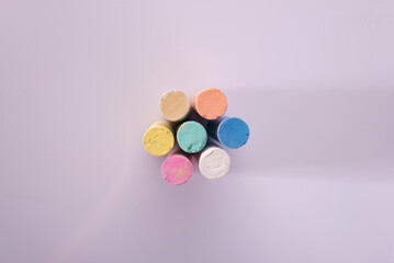 multi-colored cylindrical pastel chalk on a white background