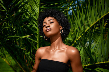 African american model tropical fashion portrait  . Beautiful woman posing  against green exotixc...