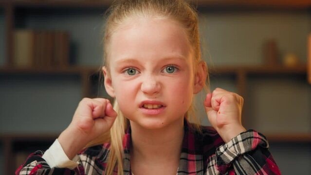 Upset angry schoolgirl little annoyed crazy teen pupil female child daughter being stressed about homework clenches small fists shake hands in anger dissatisfied with parent punishment feel annoyance