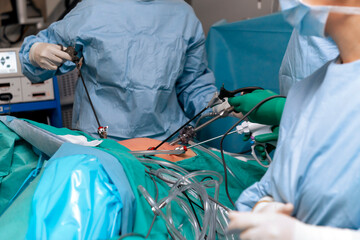 The surgeon's holing the instrument in abdomen of patient. The surgeon's doing laparoscopic surgery...